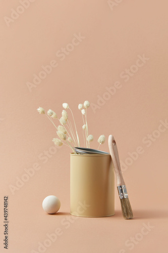 Tin of beige paint and twigs
