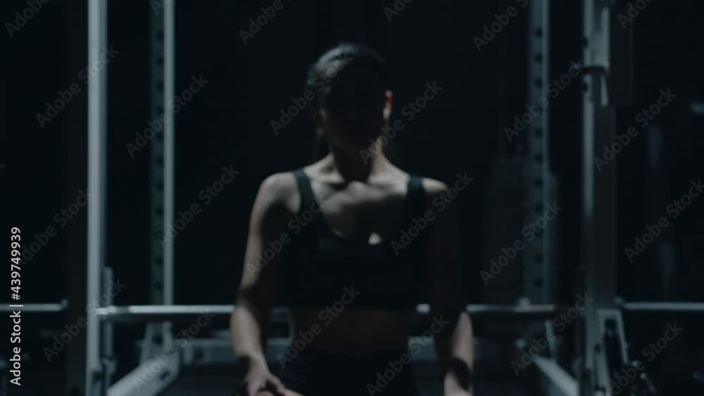 Sporty Caucasian woman sitting alone after workount in the dark gym. Sporty Caucasian woman sitting alone after workount in the dark gym.