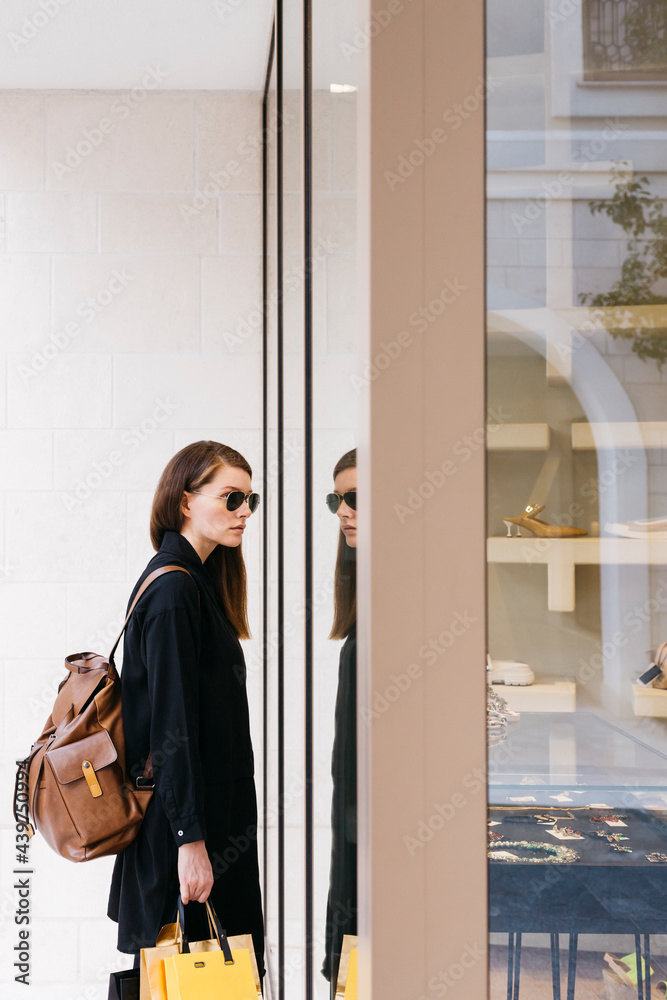 Woman stands in front of the shop window