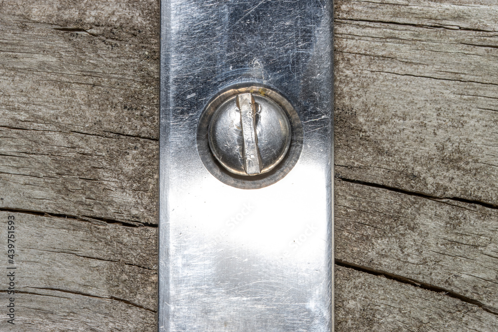 Close up shot of steel screw fixed on bracket to wood Close up shot of steel screw fixed on bracket to wood