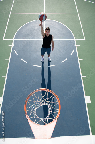 Basketball player shooting ball in hoop outdoor court. Urban youth game. Concept of sport success, scoring points and winning. © Volodymyr