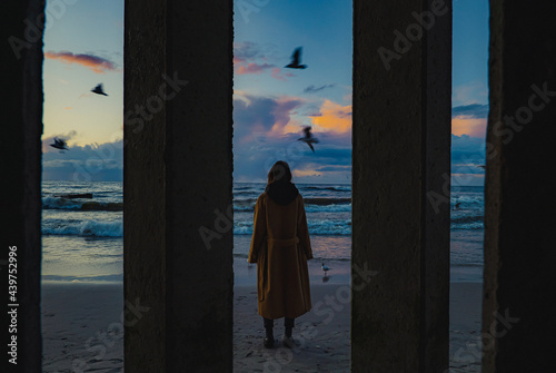 Woman in coat on the beach in the evening photo