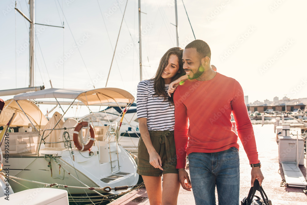 Beautiful couple walking in the port of sailboats Beautiful couple walking in the port of sailboats