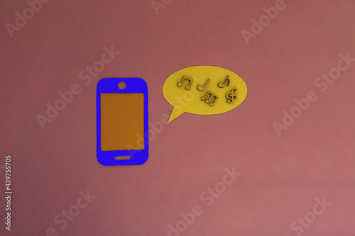 The phone is blue, an oval for text, wooden notes on a pink background. Listening to music, relaxing.