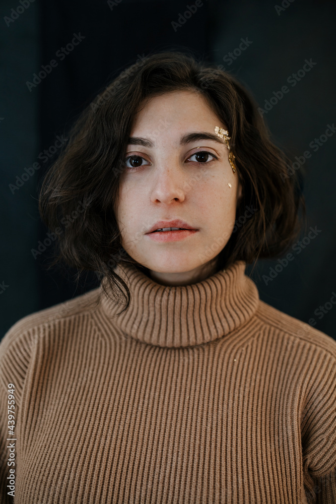Girl sweater portrait looking at the camera long dark hair gold makeup Girl sweater portrait looking at the camera long dark hair gold makeup