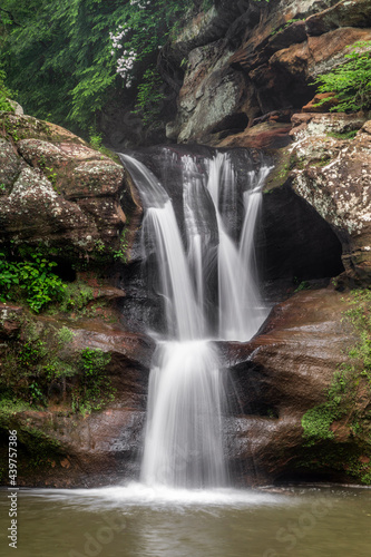 On a rainy spring day  water cascades over the sandstone cliff of the Upper Falls at Old Man   s Cave  a beautiful waterfall found in Hocking Hills State Park near Logan  Ohio.