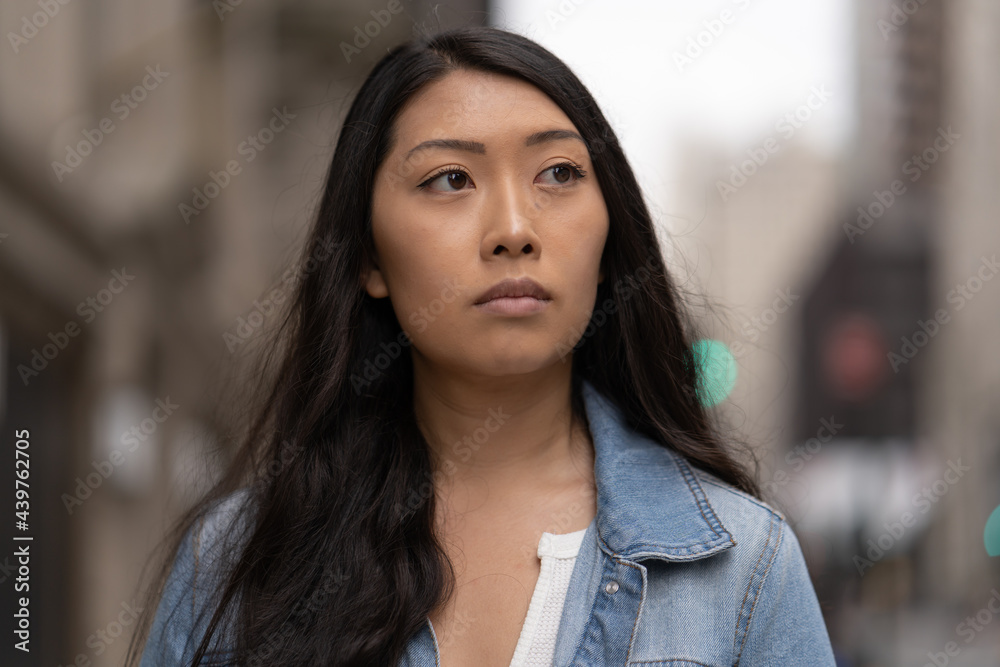 Young Asian woman in city walking street serious face Young Asian woman in city walking street serious face