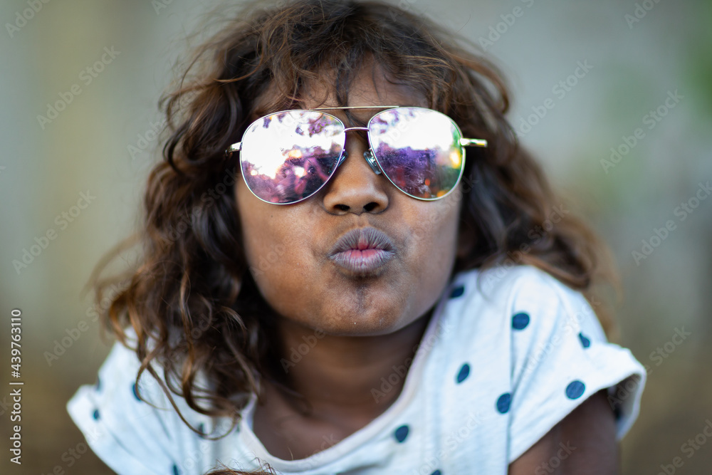 kid making kissing face while wearing mirror sunglasses kid making kissing face while wearing mirror sunglasses