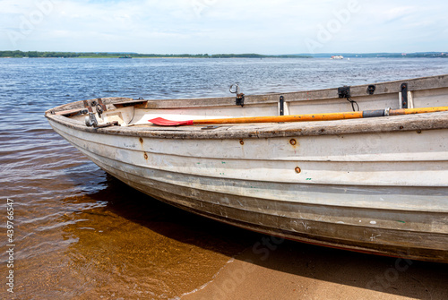 Wooden fishing boat on sandy bank of the river