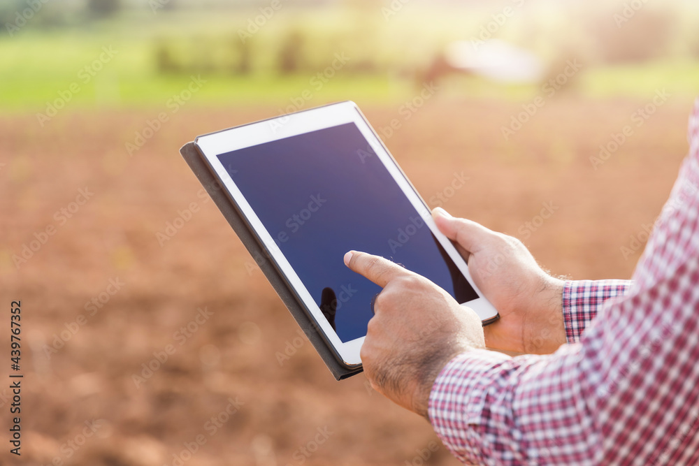 Smart farmer using a technology for studying and development agricultural. The farmer using tablet for tests the growth quality of seedling. Smart farmer using a technology for studying and development agricultural. The farmer using tablet for tests the growth quality of seedling.