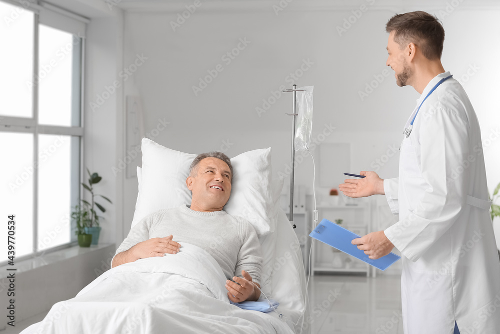 Doctor telling good news to mature man in clinic Doctor telling good news to mature man in clinic