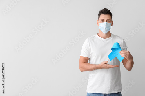 Man with blue ribbon on lig...