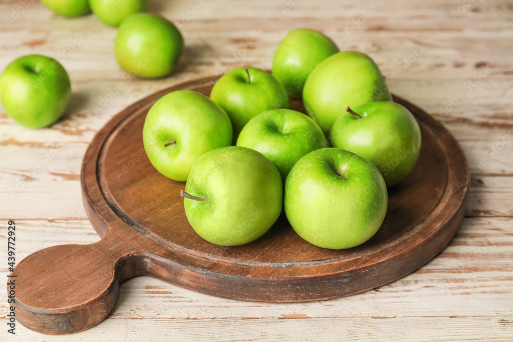 Board with fresh green apples on table Board with fresh green apples on table