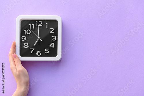 Female hand with stylish clock on color background, closeup