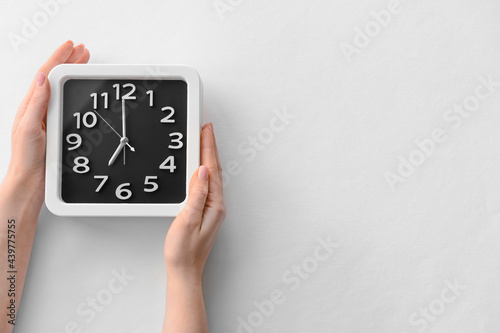 Female hands with stylish clock on grey background, closeup