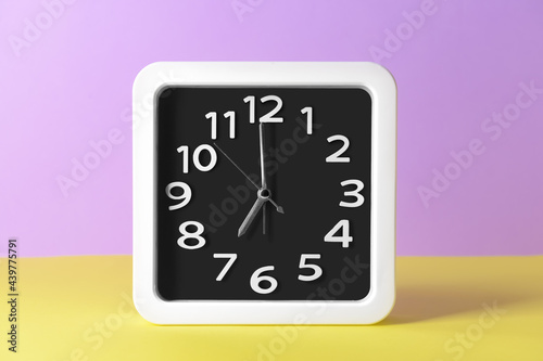 Stylish clock on color background
