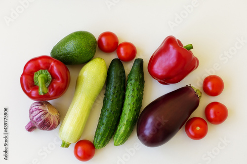 vegetables on a white background: cucumber, zucchini, garlic, eggplant, pepper, onion, avocado, tomatoes