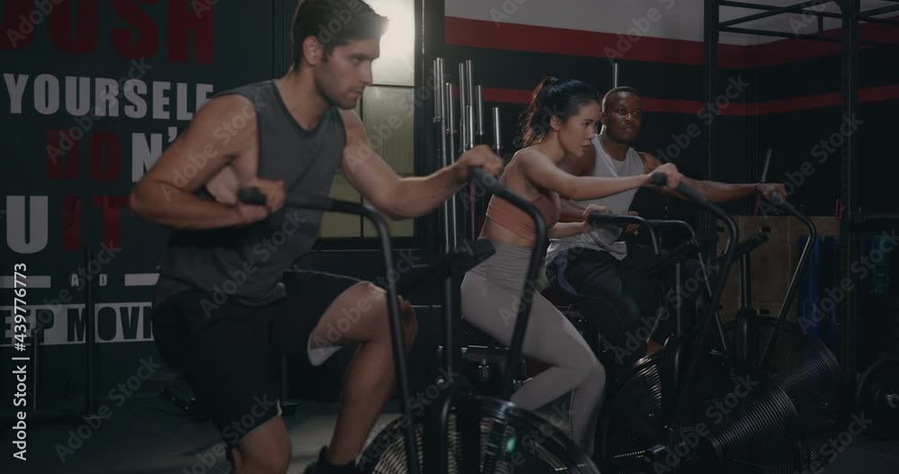 Young group fit during cardio cycling on air bike cross training at gym, People are exercising with cardio workout on spinning class in fitness club, Functional training, sport healthy lifestyle worko