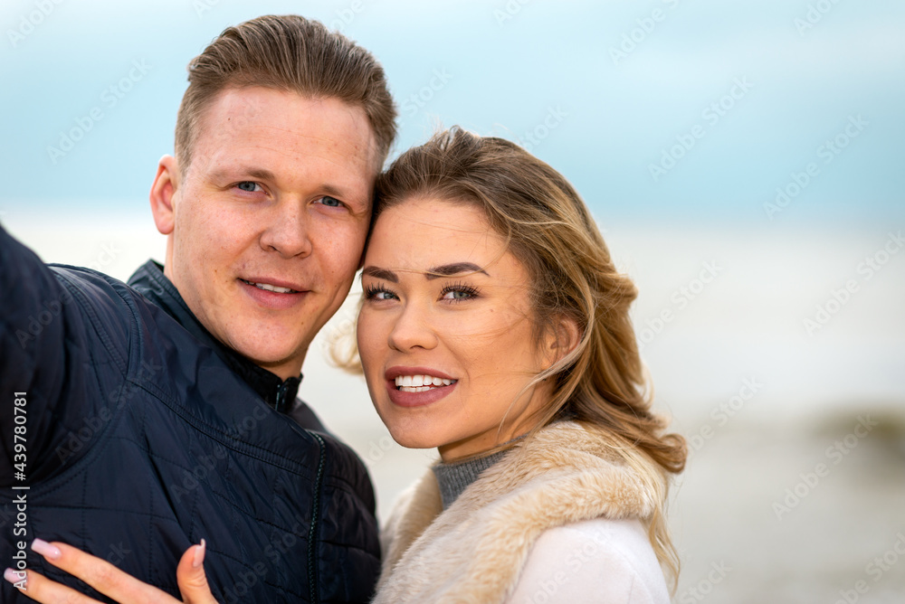 Beautiful young happy woman hugging cuddle young boyfriend while taking selfie photo on sunny beach.Close up. Beautiful young happy woman hugging cuddle young boyfriend while taking selfie photo on sunny beach.Close up.