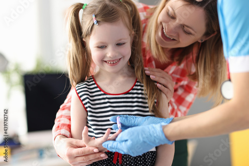 Canvas Print Taking blood from little girl's finger for laboratory analysis