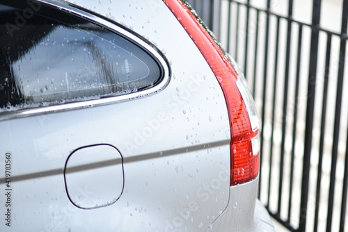 Spray water to clean the car s taillights.