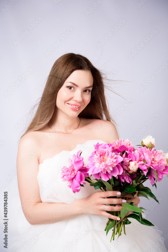 Beautiful young woman with delicate peony flower.