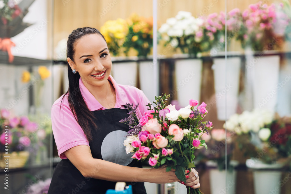 Portrait of a young florist girl with a beautiful festive bouquet in her hands. Flower shop, bouquet of flowers
