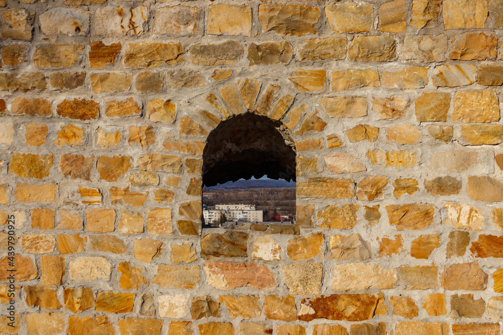 Background of the old stone wall with a loophole