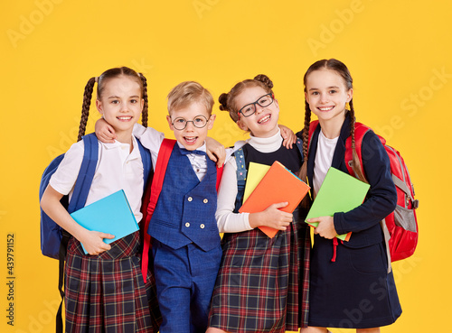 Cuadro en lienzo Group of happy schoolkids with backpacks