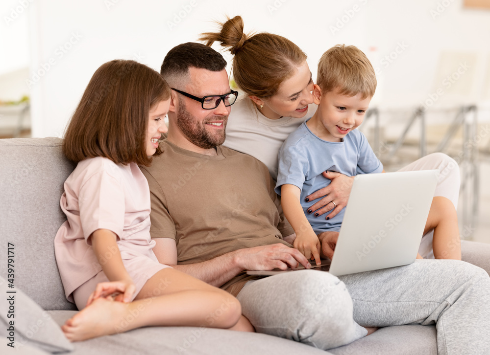 Young beautiful family using modern technologies while spending time together at home Young beautiful family using modern technologies while spending time together at home
