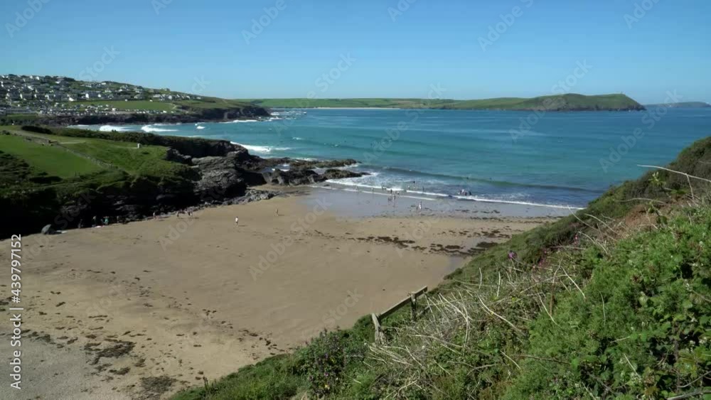 View down from cliffs onto section of Polzeath Beach and Hayle Bay in Cornwall. People enjoying the sun and swimming and surfing in the sea. 4k footage of Cornish beach in Summer View down from cliffs onto section of Polzeath Beach and Hayle Bay in Cornwall. People enjoying the sun and swimming and surfing in the sea. 4k footage of Cornish beach in Summer