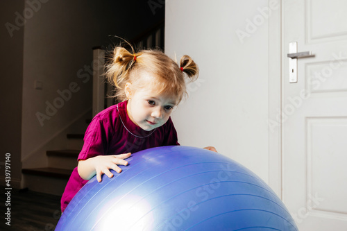 Cute kids balancing laying on large fitballs photo