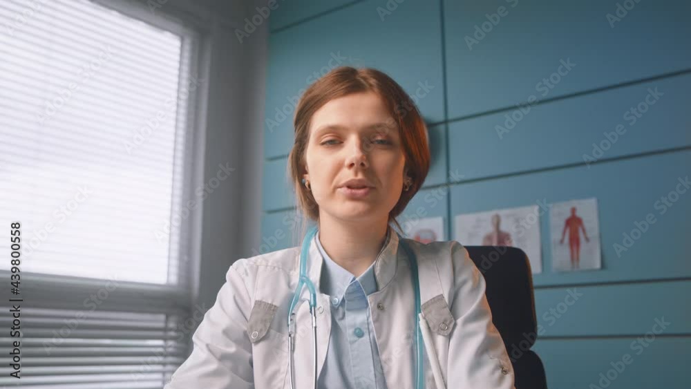 Brunette medical worker in white coat talks on video call Brunette medical worker in white coat talks on video call