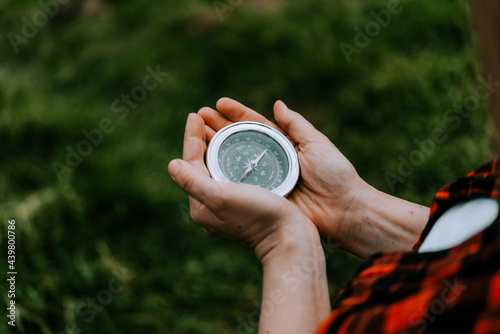 A women holds a compass in hands and is guided by the area, walk,hiking
