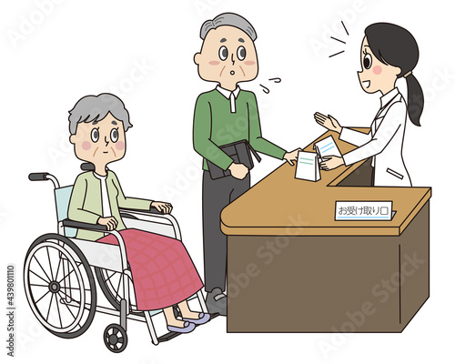 高齢の車椅子にのる妻の代わりに窓口で薬を受け取るシニア男性