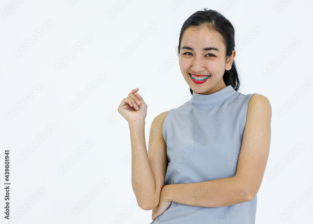 Asian girl wearing dental braces smiling happily and pose in advertising gesture on white bacground Asian girl wearing dental braces smiling happily and pose in advertising gesture on white bacground