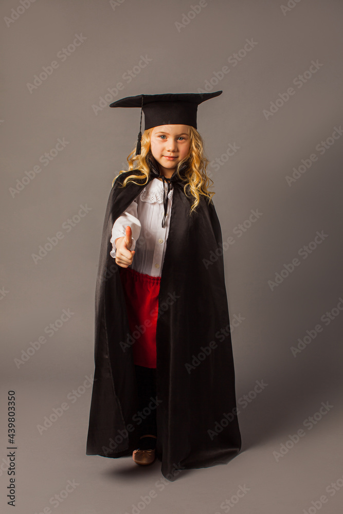 The little girl in a judge's costume shows a thumb up The little girl in a judge's costume shows a thumb up