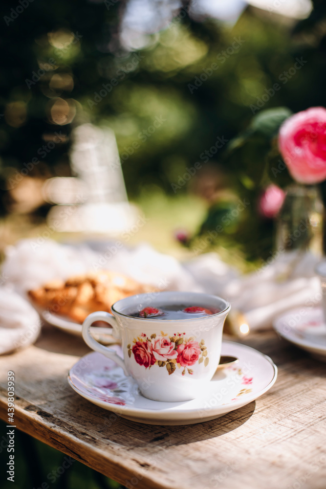 vintage cup and saucer close-up. herbal tea with fresh strawberries. tea party outdoors.