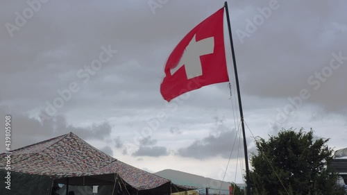 Aid station, field hospital. Surgical care to the wounded in the war. Red cross flag in the wind on mobile medical camp