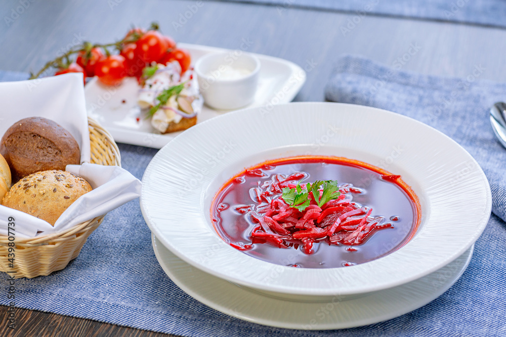 Beetroot soup, borscht, beautifully served in a white plate on the table in the restaurant. National Russian, Ukrainian cuisine. Restaurant menu Beetroot soup, borscht, beautifully served in a white plate on the table in the restaurant. National Russian, Ukrainian cuisine. Restaurant menu