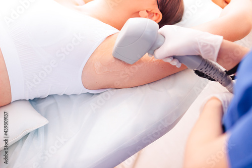 Young girl close-up receiving laser epilation of the armpit