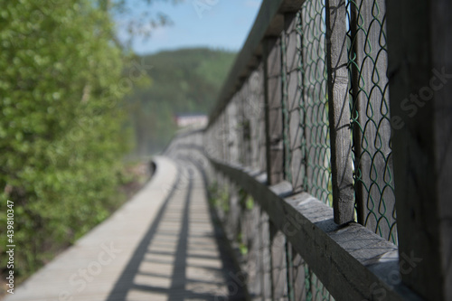 Wooden fence in the park zone next to a river.