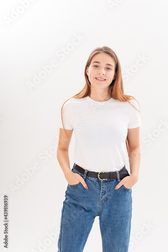 portrait of young attractive caucasian woman with long hair in t-shirt, blue jeans isolated on white studio background. skinny smiling pretty female posing on cyclorama. model tests of beautiful lady