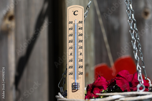 Thermometer shows high temperatures on a hot summer day photo