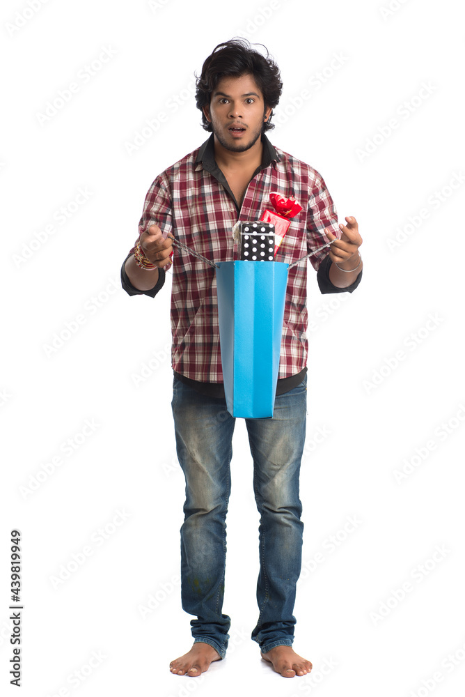 Fototapeta premium Young men showing rakhi on his hand with shopping bags and gift box on the occasion of Raksha Bandhan festival.