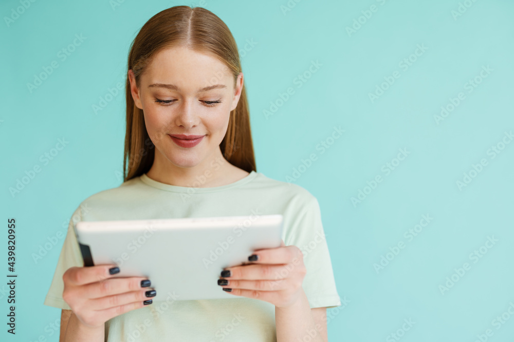 Young blonde white woman smiling while using tablet computer Young blonde white woman smiling while using tablet computer