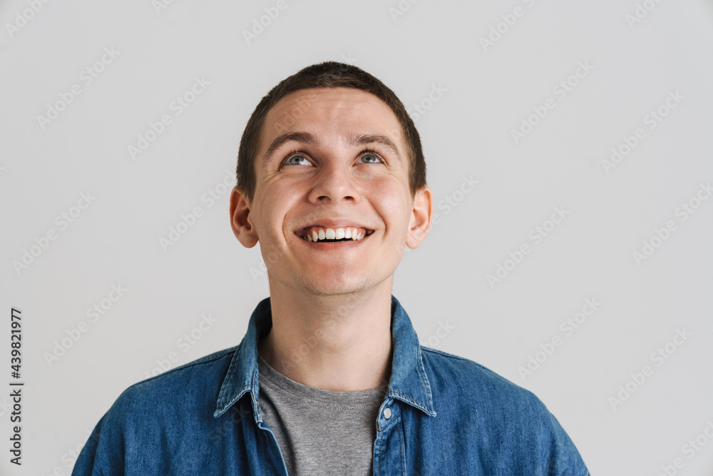 Young brunette white man smiling and looking upward - obrazy, fototapety, plakaty 