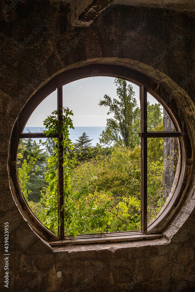 Fototapeta premium round window in an abandoned estate overlooking the sea