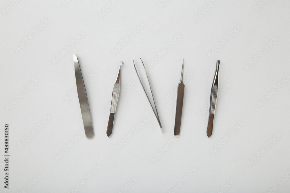 Beauty and fashion concept - tools for Eyelash Extension Procedure. Tweezers on grey background. Copyspace mockup Beauty and fashion concept - tools for Eyelash Extension Procedure. Tweezers on grey background. Copyspace mockup