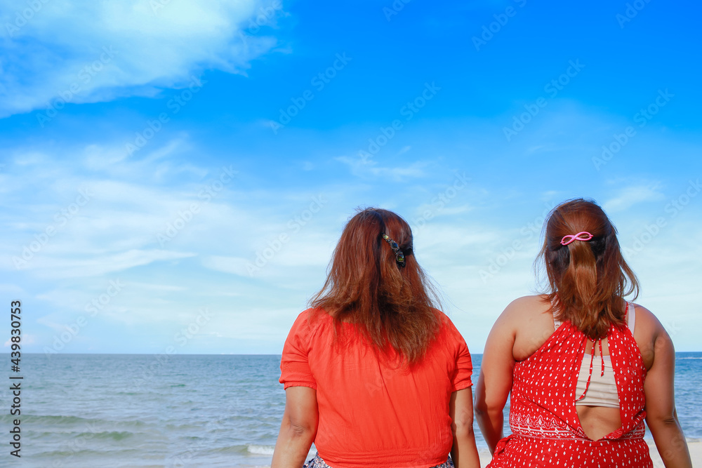 Fototapeta premium Portrait of twins asian young women at beautiful beach. Travel on vacation in summer season. Enjoy with lovely family holidays in tropical island.